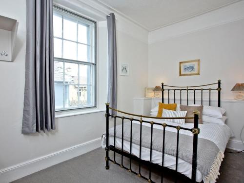 a bedroom with a bed and a window at Courts View in Newton Abbot
