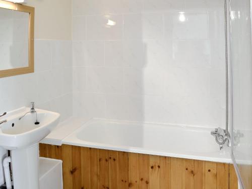 ein Bad mit einer Badewanne, einem Waschbecken und einer Dusche in der Unterkunft Primrose Cottage in Winterborne Steepleton