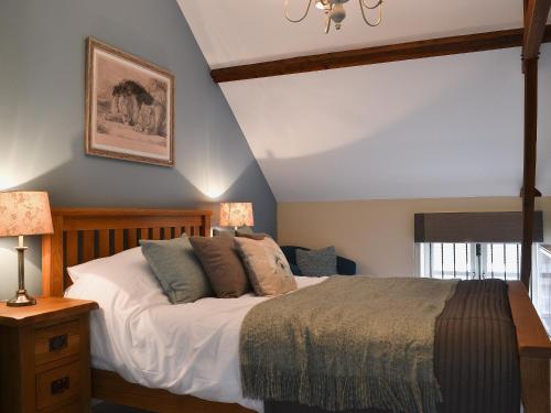 1 dormitorio con 1 cama, 2 lámparas y ventana en Red Lion Lodge en Myddle
