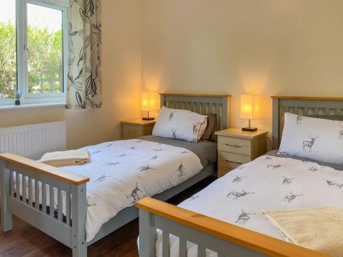 1 dormitorio con 2 camas y 2 lámparas en las mesas en Deer Cottage 1 Uk39330 en Biddenden