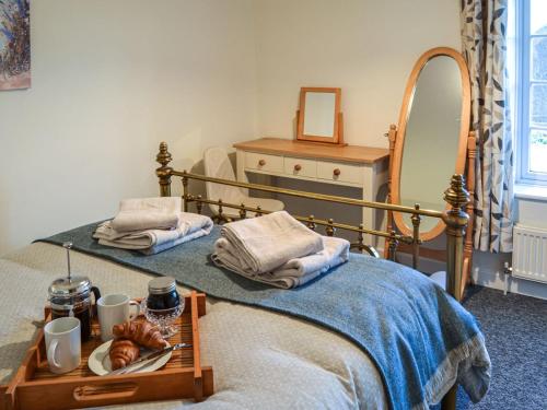 1 dormitorio con 2 camas individuales y espejo en Rosemary Cottage en Stalham