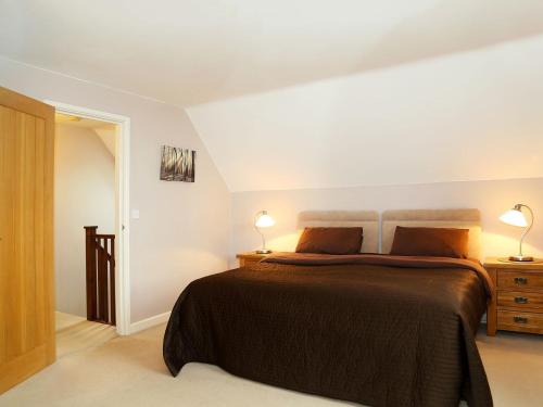 a bedroom with a bed and two lamps on a table at Harvest View, Tilmangate Farm in Ulcombe