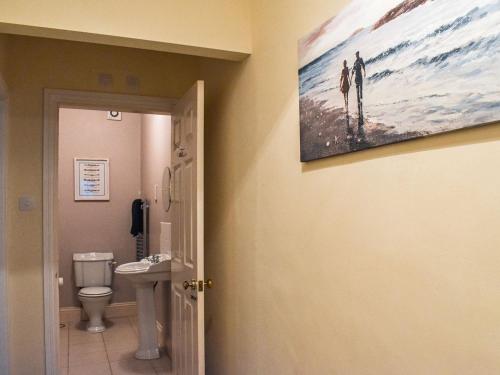 ein Bad mit einem WC und einem Wandgemälde in der Unterkunft Baileys Retreat in Sneaton