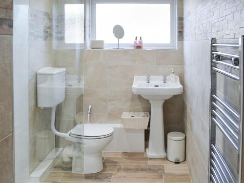 a bathroom with a toilet and a sink at Spring Tides in Beadnell