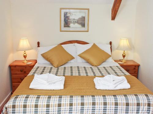a bedroom with a bed with two towels on it at The Granary Cottage in Warenford