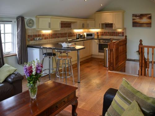 a kitchen with a center island in a living room at Aprils Cottage in Kilkhampton