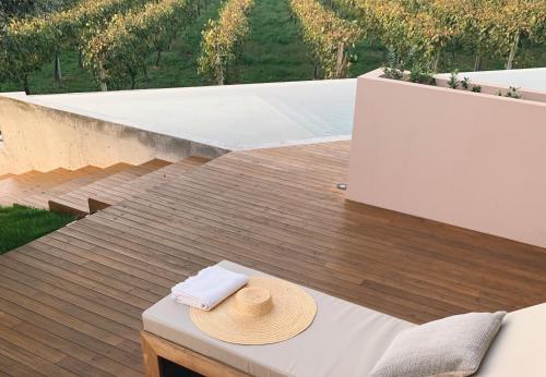 a hat and a towel on a table on a deck at Vinha by NHôme in Ponte de Lima
