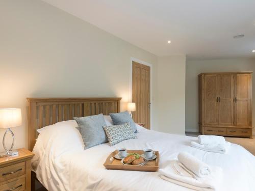 a bedroom with a bed with a tray of food on it at Property 2 in Wroxall