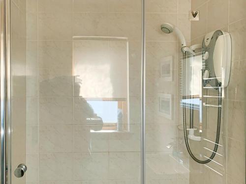 a bathroom with a shower with a glass door at Crossburn Hideaway in Helensburgh