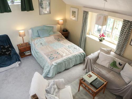 a bedroom with a bed and a couch and a chair at Garden Flat in Pilton