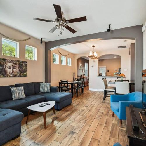 a living room with a blue couch and a table at 2 King Bed Hot Tub Home in Tampa