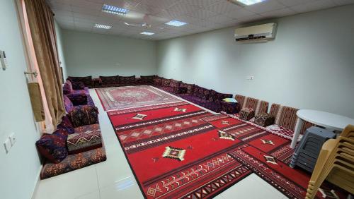 una sala de conferencias con una alfombra roja en el suelo en مزرعة الطيبين, en Buraidah