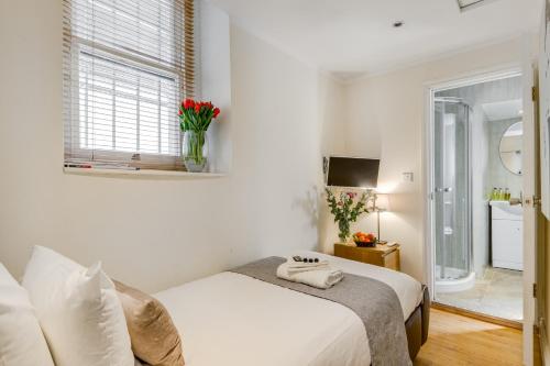 Habitación blanca con cama y ventana en 1 Lexham Gardens Hotel, en Londres