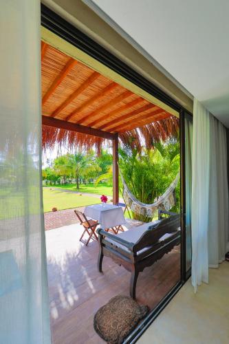 a patio with a hammock and a table and chairs at Bahay Tatu in Pôrto de Pedras