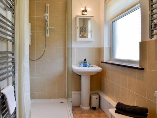 uma casa de banho com um lavatório, um chuveiro e um WC. em Melbreak em Lorton