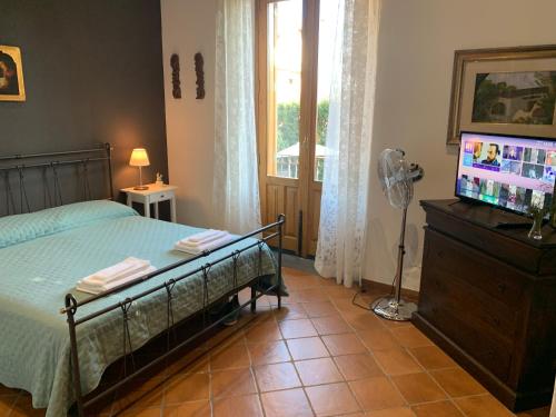 een slaapkamer met een bed en een flatscreen-tv bij Casa Gino Petrulli Etna, villa con piscina in Zafferana Etnea