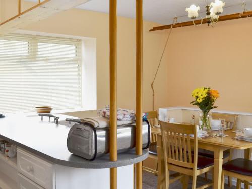 una cucina e una sala da pranzo con tavolo di The White Cottage a Furness Vale