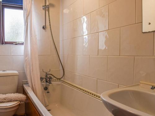 a bathroom with a tub and a toilet and a sink at Over Across-uk38277 in Cloughton