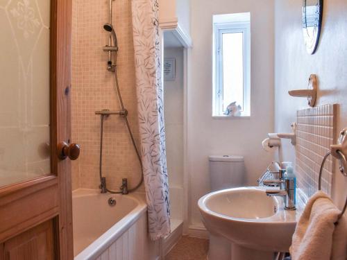 a bathroom with a sink and a tub and a toilet at Holly Cottage in Brotton