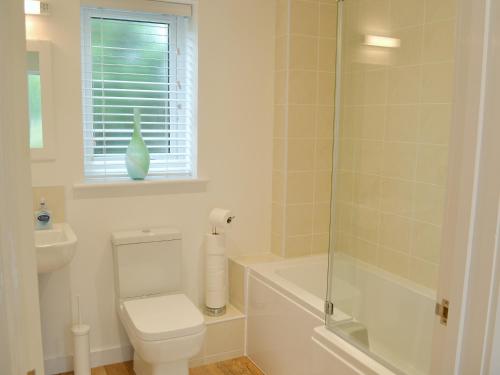 a bathroom with a toilet and a glass shower at Tegen in Tywardreath