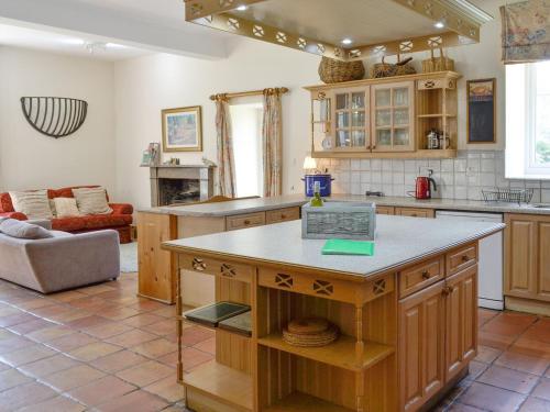 a kitchen with an island in the middle of a room at Crogen Coach House - Oqr in Llandrillo