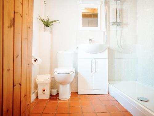 a bathroom with a toilet and a sink and a tub at Goose Cottage- Uk6737 in Lydstep