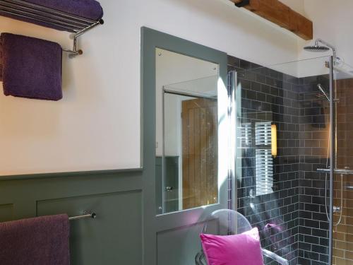 a bathroom with a mirror and a glass shower at The Stables in Berwick Hill