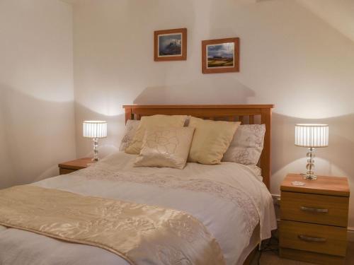a bedroom with a bed with two nightstands and two lamps at The Nook in Kirkby Lonsdale