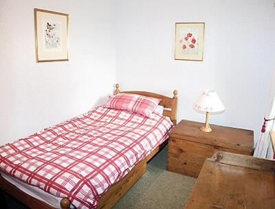 1 dormitorio con 1 cama y 1 mesa con lámpara en The Cottage, en Ankerville