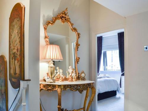 een kamer met een spiegel en een tafel met een lamp bij Cross Cottage in Haworth