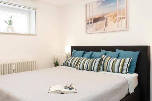 ein Schlafzimmer mit einem Bett mit einem Buch darauf in der Unterkunft Moderne Ferienwohnung Grömitz mit Garten/Terrasse in Grömitz