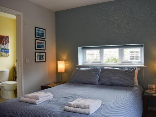 een slaapkamer met een bed met twee handdoeken erop bij Mussel Cottage in Middleton-on-Sea