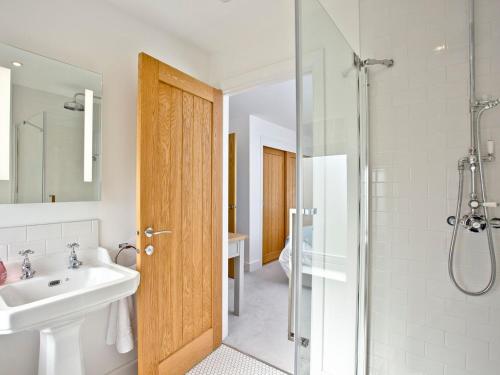 a bathroom with a white sink and a shower at Oakwood in Saint Endellion