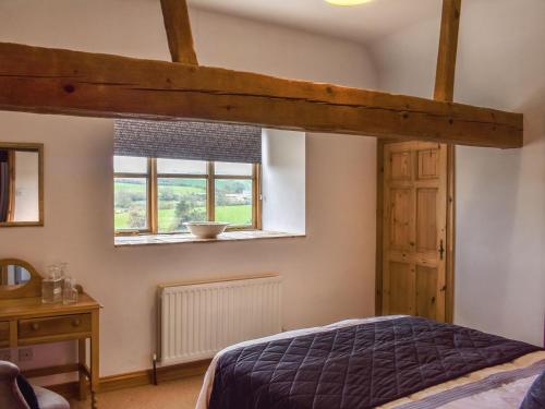 a bedroom with a bed and a window at Grove Barn in Carisbrooke