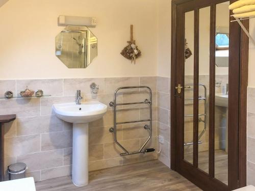 a bathroom with a sink and a shower at Forge Mill Cottage in Dalbeattie