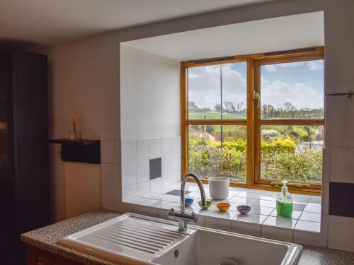 a kitchen with a sink and a window at Grove Barn in Carisbrooke