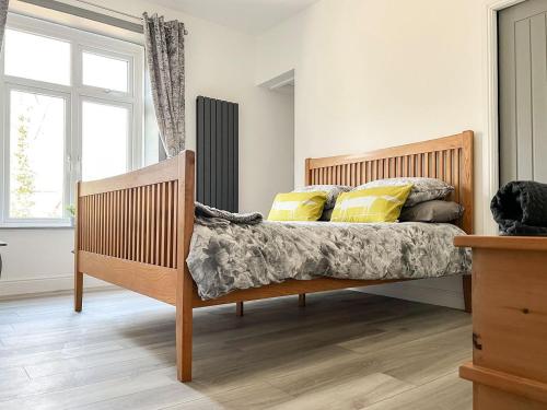 a bedroom with a wooden bed with yellow pillows at Redmonds Retreat in Chinley
