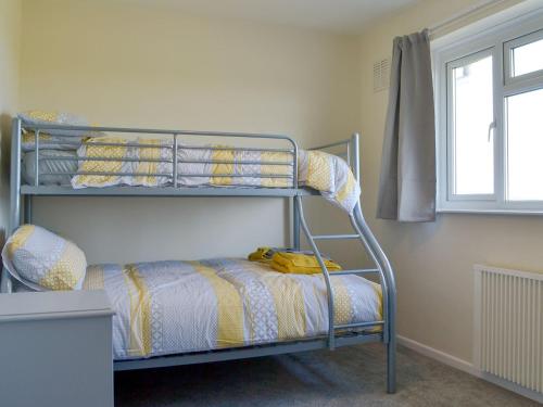 a bedroom with a bunk bed and a window at Valley View in Morwenstow