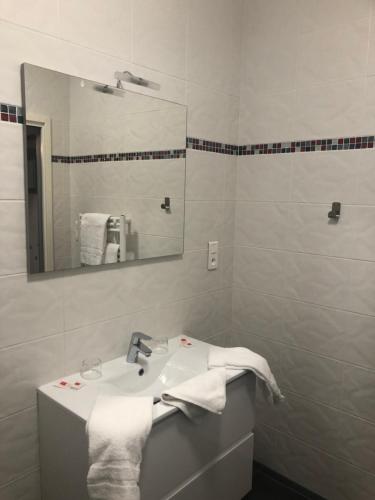 a white bathroom with a sink and a mirror at L'auberge de l'abbaye in Sorde-lʼAbbaye