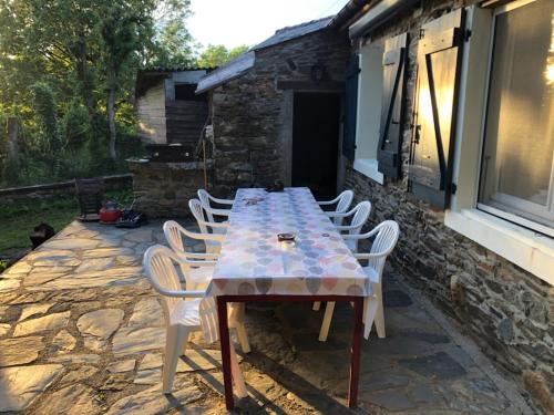 - une table et des chaises sur une terrasse en pierre dans l'établissement Maison de campagne, à Paulinet