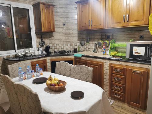 een keuken met een tafel en een fruitschaal bij Appartement F4 de Luxe in Constantine