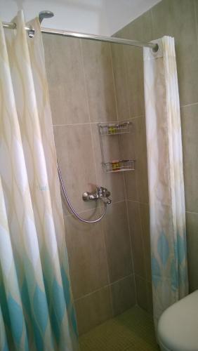 a shower with a shower curtain in a bathroom at Anemomilos Villa in Firostefani