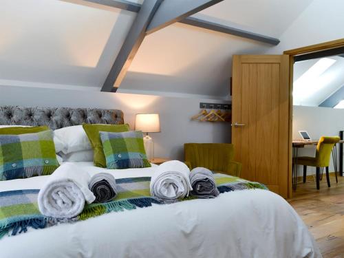 1 dormitorio con 1 cama con toallas en Maes Merlin, en Llanddeusant