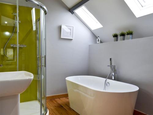 een badkamer met een bad en een wastafel bij Maes Merlin in Llanddeusant