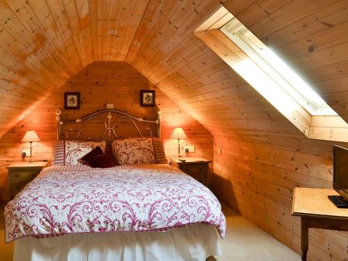 Acorn Barn في Foggathorpe: غرفة نوم بسرير في كابينة خشبية