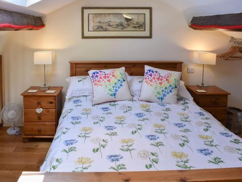 Un dormitorio con una cama con sábanas y almohadas azules y blancas en The Carriage House en Watermillock