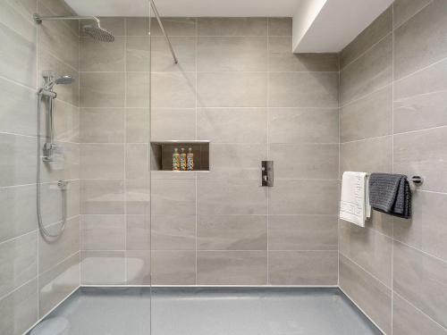 een badkamer met een douche en een glazen deur bij The Stables in Stanhope