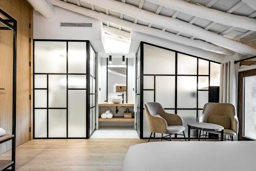 a bedroom with glass doors and chairs and a bed at ABBI Suites Casa Rural, Suites & Spa in Bocairent
