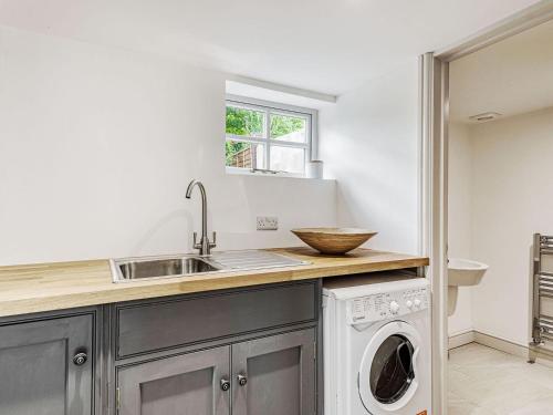 a kitchen with a sink and a washing machine at The Granary in Braunston