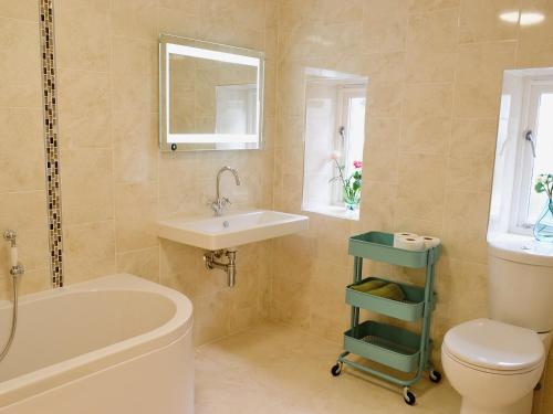 a bathroom with a sink and a toilet and a tub at Bowji in St Just